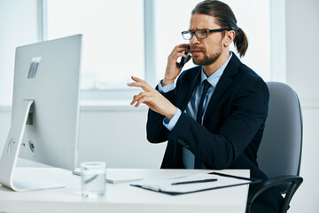 male manager sitting at a desk in front of a computer executive