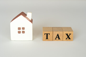 家の税金のコンセプト（ミニチュアの家とTAXの文字）