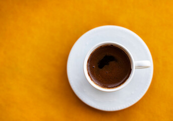 cup of coffee. Black Coffee in a Cup of coffee from above, on an Orange background. Good morning.