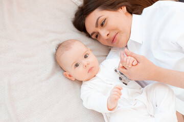 mom and baby are lying on the bed in the bedroom