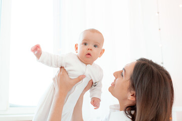 mom and baby playing in the bedroom, holding in her arms