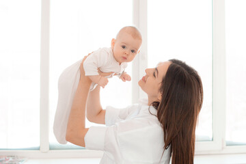 mom holds the baby in her arms at home