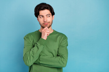 Photo of young thoughtful minded smiling guy thinking look copyspace dreaming isolated on blue...