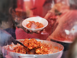 cook serving a traditional italian fresh pasta dish called orecchiette al pomodoro
