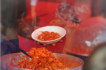 cook serving a traditional italian fresh pasta dish called orecchiette al pomodoro