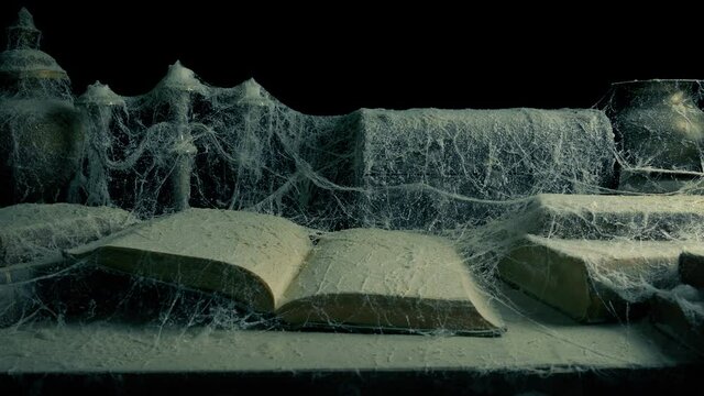Open Book Covered In Cobwebs And Dust Moving Shot