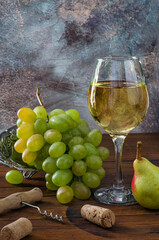 Wine in aglass and bunch of grapes on the table