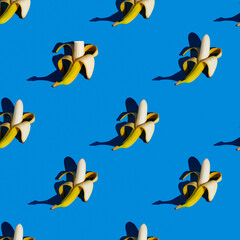 Fototapeta premium flat seamless pattern of peeled bananas on a blue background