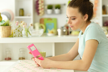 Fototapeta premium Portrait of girl using smartphone at table