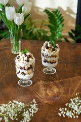 Eton Mess. Trifle with meringue, blueberries, pistachios and mint. Dessert in a glass. Side view....