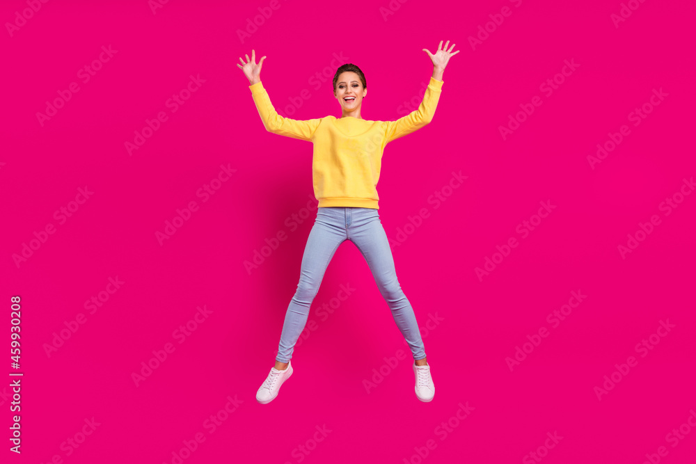 Wall mural Photo of sweet funny young lady wear yellow jumper smiling jumping high like star isolated pink color background