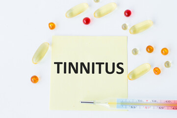 On the card text TINNITUS, next to the thermometer and yellow tablets.