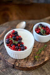 Panna cotta with berries. Wooden background. Side view.