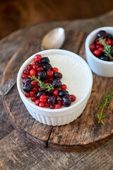 Panna cotta with berries. Wooden background. Side view.