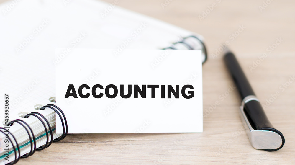 Poster on the card the text of accounting, next to the pen and notepad on the table