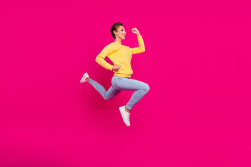 Fototapeta na wymiar Photo of funny charming young woman dressed yellow pullover jumping running fast smiling isolated pink color background