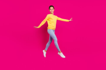 Fototapeta na wymiar Photo of sweet pretty young lady wear yellow jumper smiling jumping walking isolated pink color background
