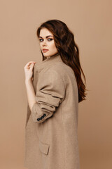 sexy brunette makeup and beige coat side view