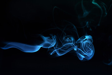 Abstract colored smoke moves on dark background. Wallpaper. Personal vaporizers fragrant steam. Concept of alternative non-nicotine smoking. E-cigarette. Texture. Design elements.