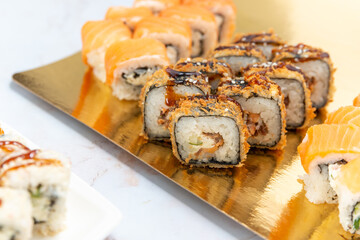 sushi rolls on a gold plate on a white background