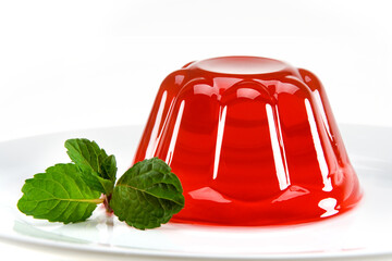 Gelatina de fruta vermelha com ramo de hortelã ao lado em fundo branco para recorte. - obrazy, fototapety, plakaty