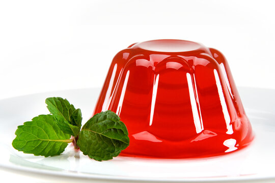 Gelatina de fruta vermelha com ramo de hortel&atilde; ao lado em fundo branco para recorte.