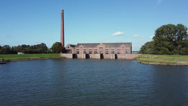 The Woudagemaal is the largest steam pumping station ever built in the world. Located in Lemmer in the Netherlands, aerial backwards over lake