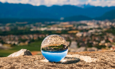 Fototapeta na wymiar Crystal ball alpine landscape shot at the famous Landskron castle ruins, Villach, Kaernten, Austria