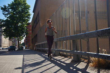 Dedicated young woman running alone outdoors