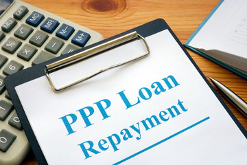 PPP loan repayment form and clipboard with calculator.