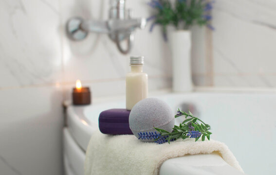 The concept of Spa beauty. Close-up of a lilac bath ball with lavender, an aromatic candle in the bathroom. The concept of therapy. Taking a relaxing bath.Home spa products