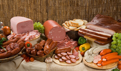 Composição com produtos embutidos, linguiça, bacon, presunto, salsichas em mesa rústica. - obrazy, fototapety, plakaty