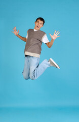 Obraz premium Portrait of young man, student or boy in casual clothes isolated on blue studio backgroud. Human emotions concept.