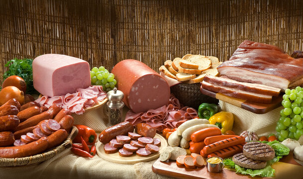 Composi&ccedil;&atilde;o com produtos embutidos, lingui&ccedil;a, bacon, presunto, salsichas em mesa r&uacute;stica.