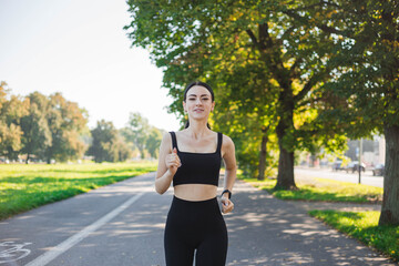 Athletic young happy woman runing in the park jogging in the morning for lifestyle health. Outdoor workout. Sport and healthy active lifestyle concept. Black clothing for sports