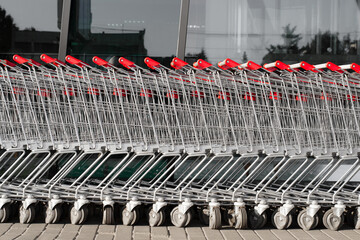 Row of shopping carts stand outside on a sunny day