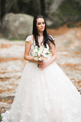 Fototapeta na wymiar Luxury wedding bride, girl posing and smiling with bouquet