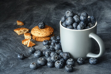 Fresh juicy blueberries in the bowl on the black background.