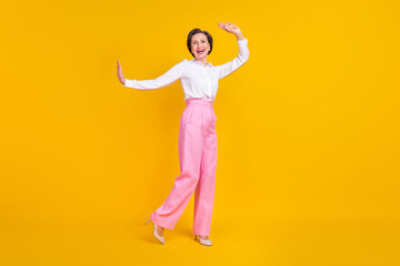 Fototapeta na wymiar Photo of funny adorable age woman dressed white shirt dancing smiling isolated yellow color background