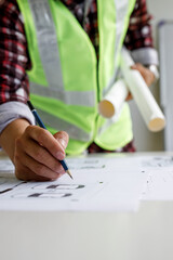 Architect design engineer working drawing sketch plans blueprints and making architectural...