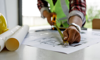 Architect design engineer working drawing sketch plans blueprints and making architectural construction model in a home office. Concept architects, Selective Focus