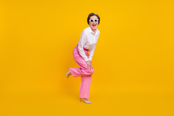 Fototapeta na wymiar Full length photo of aged excited woman happy positive smile have fun isolated over yellow color background