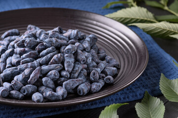 honeysuckle berry in a black plate stands on a blue napkin
