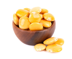 Pickled yellow lupine beans in wooden bowl, isolated on white background. Tournus, preserved lupinus.