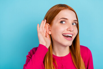 Photo of young excited millennial red head lady hand ear wear pink sweater isolated on blue color...