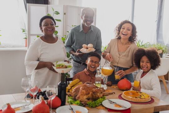 Cheerful african american family celebrating thanksgiving near food at home - Powered by Adobe