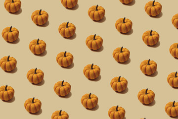 Autumn pattern in yellow and orange colour. Halloween mini pumpkins minimal background. Creative layout.