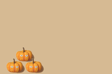 Autumn pattern in yellow and orange colour. Halloween mini pumpkins minimal background. Creative layout. Happy smiling pumpkin face.