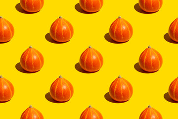 Seamless pattern of ripe juicy whole autumn orange pumpkins on yellow background - obrazy, fototapety, plakaty