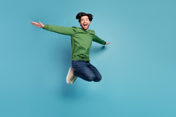 Obraz premium Full size photo of excited crazy cheerful man feeling freedom jumping in air isolated on blue color background